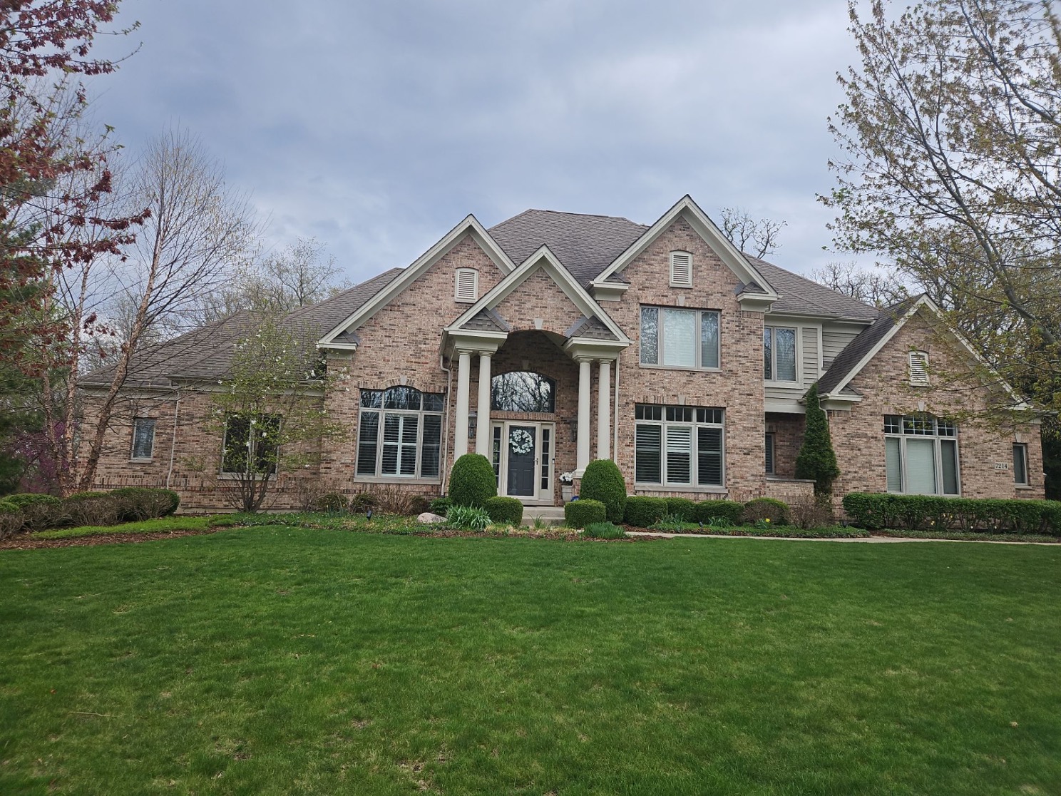 Large brick two-story DFW home with a completed asphalt shingle roof