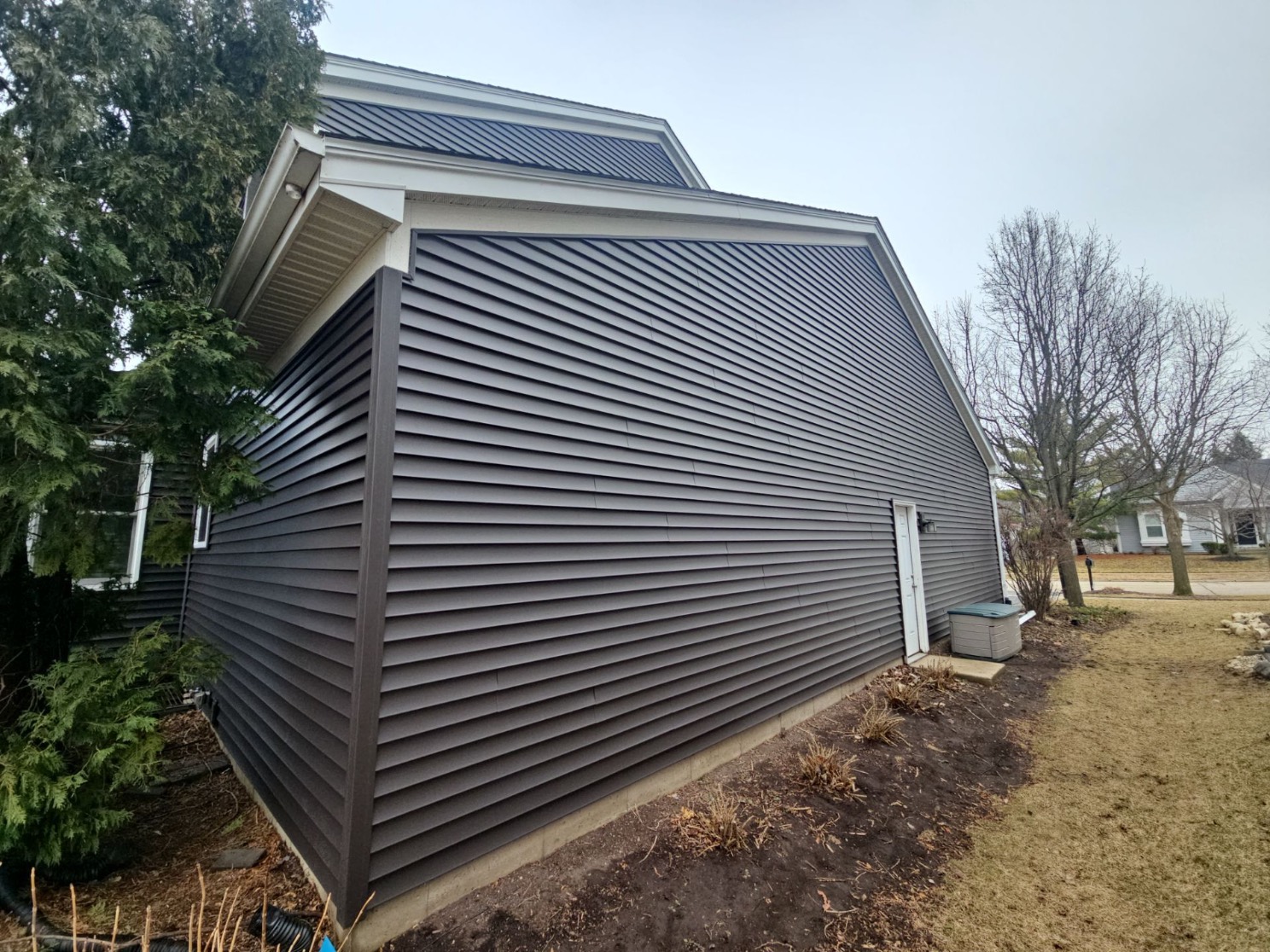 Home with new charcoal-gray siding installed by Complete Contractor Group
